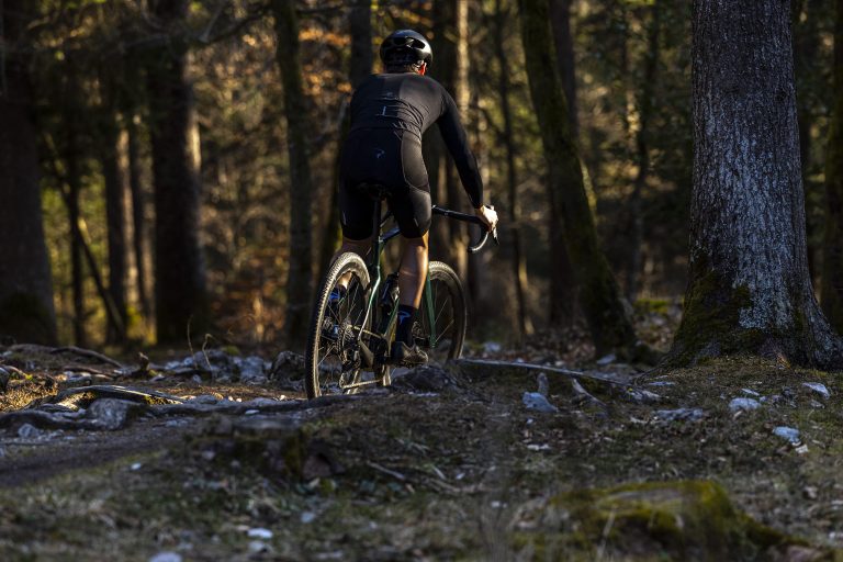 Man riding gravel bike in the woods. Get your bike at Central Cycles today!